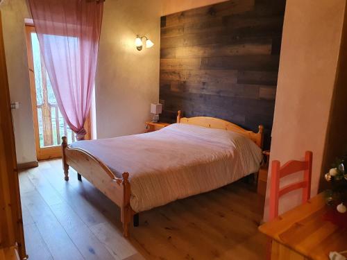 a bedroom with a bed and a wooden wall at Agriturismo al pra di muriet in Susa