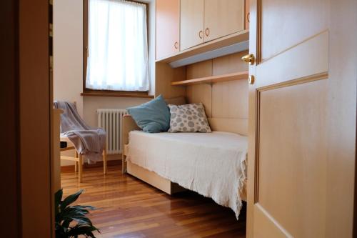 a small bedroom with a bed and a window at Casa Mottes in Fai della Paganella