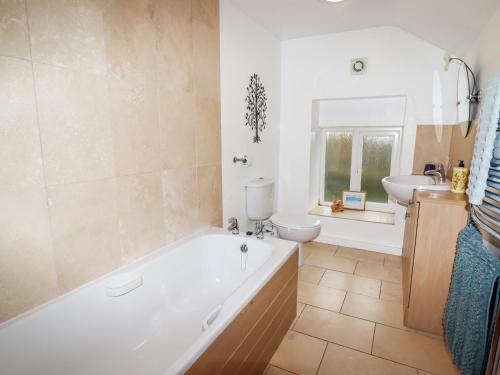 a bathroom with a tub and a toilet and a sink at South Hillswood Farm in Leek