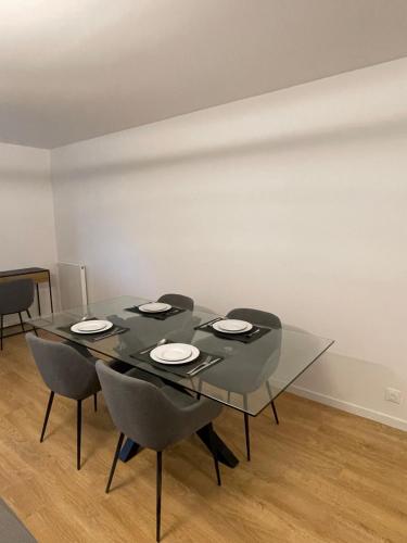 a dining room with a black table and chairs at Appartement Saint ouen proche stade de france in Saint-Ouen
