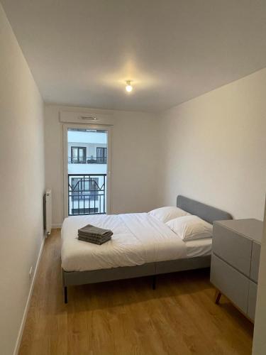 une chambre avec un lit et une fenêtre dans l'établissement Appartement Saint ouen proche stade de france, à Saint-Ouen