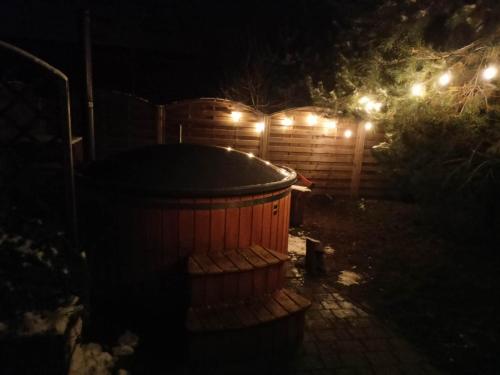 a bath tub in a backyard at night at Kaszuby wczasy u Danusi sauna i bania in Lipusz