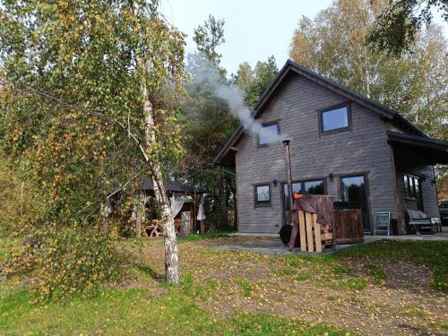 a house with smoke coming out of it at Kaszuby wczasy u Danusi sauna i bania in Lipusz