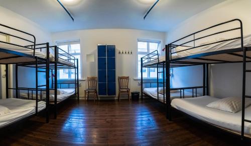 a room with four bunk beds and a wooden floor at Akureyri Backpackers in Akureyri