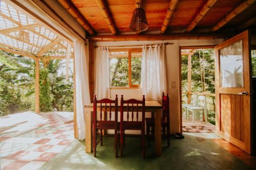 comedor con mesa, sillas y ventanas en Designers Luxury Retreat with breathtaking gardens, en Tzununá