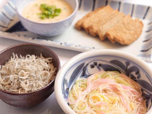 a table with bowls of noodles and a bowl of soup at Matsuyama Tokyu REI Hotel in Matsuyama