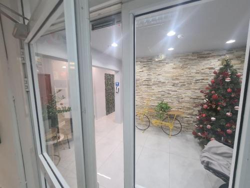 a christmas tree in a room with a glass door at Maya New Guest House -Panoramic Sea&CityCentre View, Haifa in Haifa
