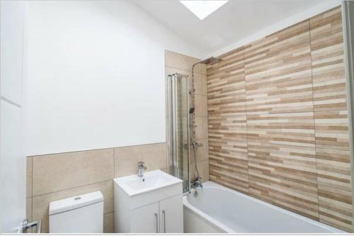 a bathroom with a tub and a toilet and a sink at Impeccable 1-Bed Apartment in Buxton Town Center in Buxton