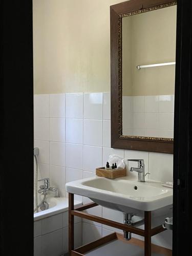 un bagno con un lavandino, uno specchio e una vasca di La Maison Du Village a Val-de-Dagne