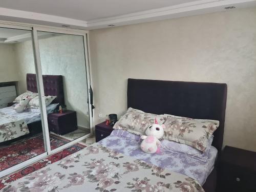 a teddy bear sitting on a bed in a bedroom at بالوما in Temara