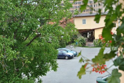 a blue car parked in a parking lot next to a building at Vila Veche in Haţeg