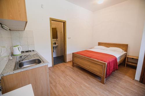a small bedroom with a bed and a sink at Mojčin Pisker Apartment House in Kranj