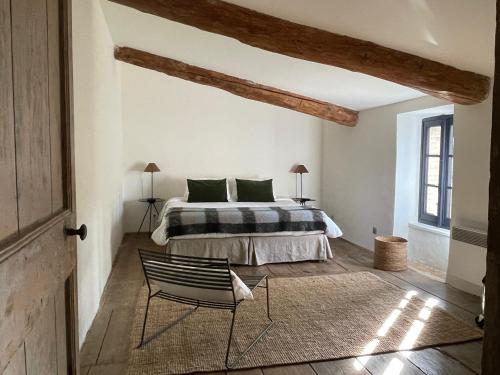 a bedroom with a bed and a chair at La Maison Du Village in Val-de-Dagne