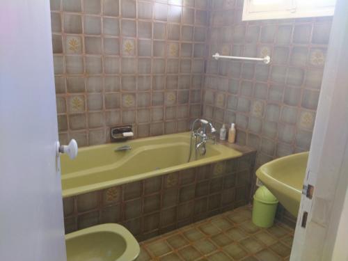 een badkamer met een bad, een toilet en een wastafel bij paradis des randonneurs in Roquefort-des-Corbières