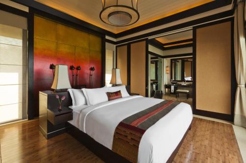 a bedroom with a large bed and a living room at Banyan Tree Lang Co in Lang Co