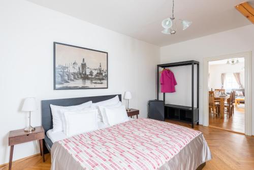 a bedroom with a bed and a dining room at St. George Apartments in Prague