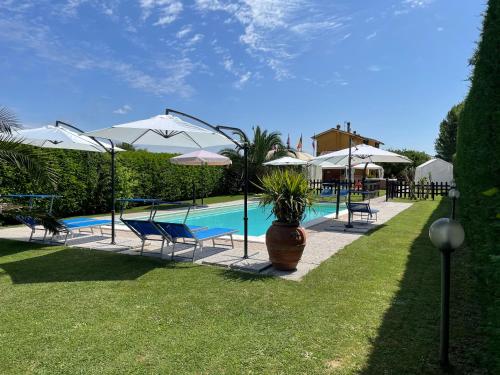 - une piscine avec des chaises longues et des parasols dans l'établissement Agriturismo La Conte, à Lucques