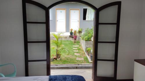 una puerta abierta a un jardín visto desde un dormitorio en Studio Kitsossego V, en Curitiba
