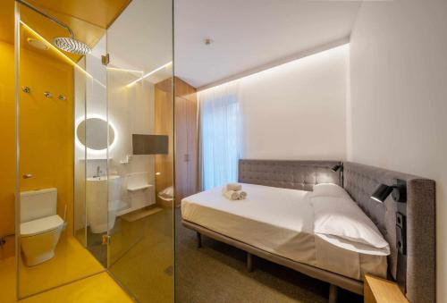 a bedroom with a bed and a bathroom with a shower at Nature by Raidom in Alicante