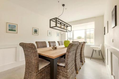 a dining room with a wooden table and chairs at Maison Mathieu in Bilzen