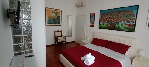 a bedroom with a bed with red and white pillows at Casa Flora in Taranto