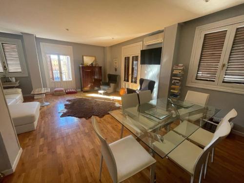 a living room with a glass table and chairs at Catedral Plaza in Murcia