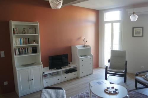 salon z telewizorem i białym centrum rozrywki w obiekcie KAZADIZA Superbe T4, classé 3 étoiles, sur le port w mieście Port-Vendres