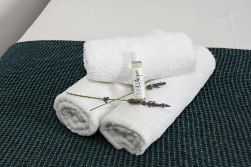 un asciugamano con una bottiglia di sapone e fiori di OnQ Accommodation a Bellville