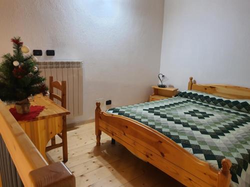 a bedroom with a wooden bed and a christmas tree at Agriturismo al pra di muriet in Susa