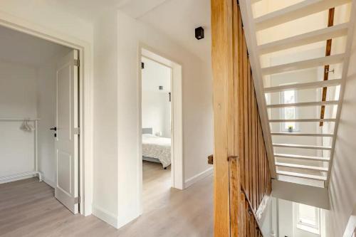 a hallway with a stairway leading to a bedroom at Maison Mathieu in Bilzen