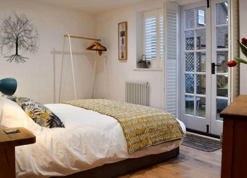 - une chambre avec un lit doté d'une couverture jaune dans l'établissement The Snug Entire home Sleeps 2, Stratford upon Avon, à Shottery