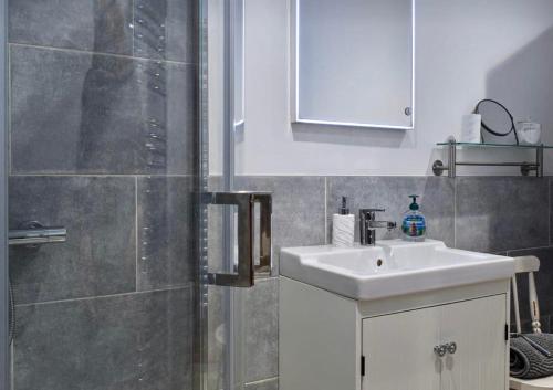 uma casa de banho com um lavatório branco e um chuveiro em The Snug Entire home Sleeps 2, Stratford upon Avon em Shottery