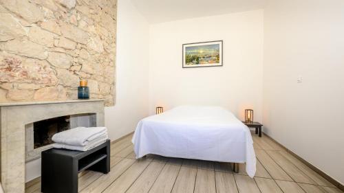 Habitación blanca con cama y chimenea en Guest House Maccarani, en Niza