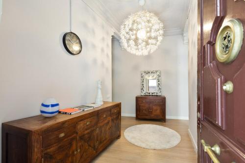 a room with a wooden dresser and a chandelier at Sagrada Familia IV by Enjoy Apartments in Barcelona