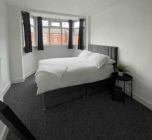 a bedroom with a large bed with a window at Lovely 3 Bedroom property with extensive parking in Birmingham