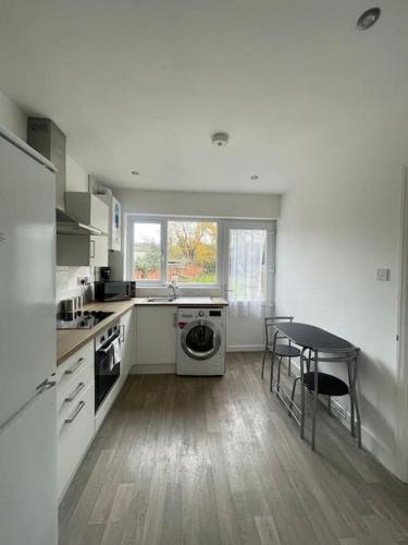 a kitchen with white appliances and a table and a table at Lovely 3 Bedroom property with extensive parking in Birmingham