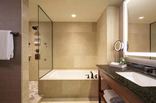 a bathroom with a tub and a sink and a shower at Omni Fort Worth Hotel in Fort Worth