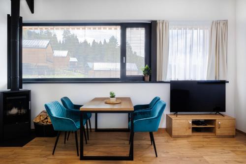a living room with a table and chairs and a television at TRI VODY Demänovská Dolina in Liptovský Mikuláš