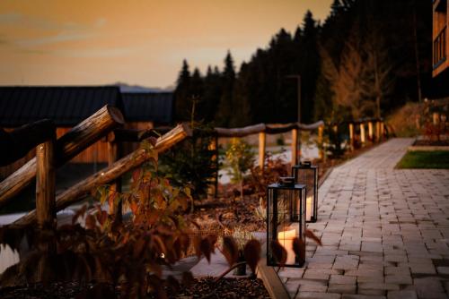 a brick sidewalk next to a fence with trees at TRI VODY Demänovská Dolina in Liptovský Mikuláš