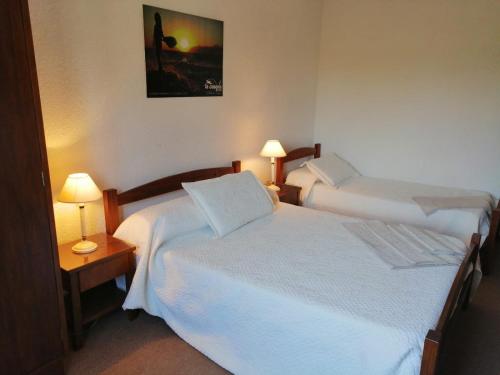 Hotel La Casona في لا بالوما: سريرين في غرفة الفندق مع مصباحين