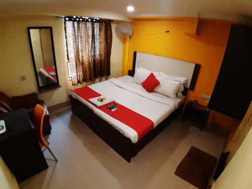 a bedroom with a large bed with red and white pillows at Hotel Akash inn in Chennai