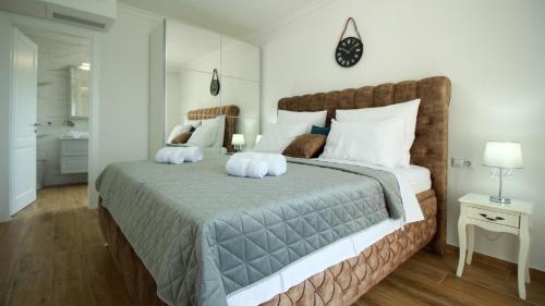una camera da letto con un grande letto con cuscini bianchi di Villa Sara a Sveti Ivan