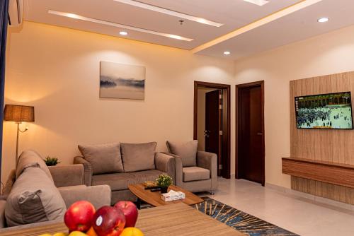 a living room with a couch and a tv at idles By Staytion Serviced Apartments in Jeddah