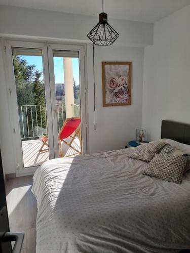une chambre avec un lit et une porte coulissante en verre dans l'établissement Appartement 2 pièces tout confort, à Saint-Raphaël