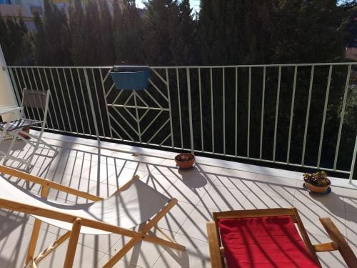 une terrasse avec des chaises et un seau sur une clôture dans l'établissement Appartement 2 pièces tout confort, à Saint-Raphaël