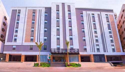 a large building with palm trees in front of it at idles By Staytion Serviced Apartments in Jeddah