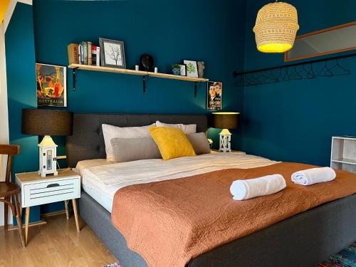 ein Schlafzimmer mit einem großen Bett mit blauer Wand in der Unterkunft Light and Bright Central in Pristina