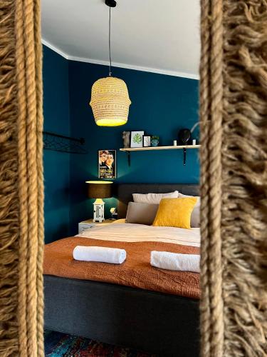 a blue bedroom with a bed with towels on it at Light and Bright Central in Pristina
