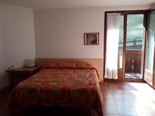 a bedroom with a bed and a large window at Apartments "STELLA ALPINA" in Santa Caterina Valfurva