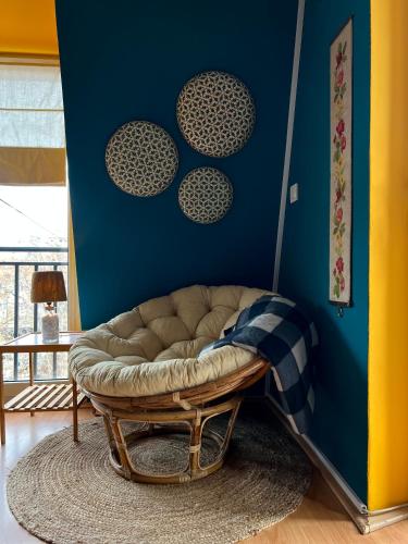 a living room with a couch and a blue wall at Light and Bright Central in Pristina